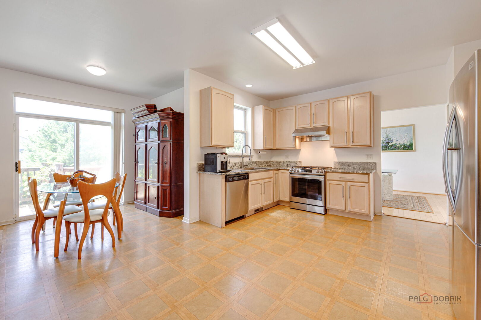 2227 Trailside Lane Wauconda, IL 60084 - Photo 17 of 37 a kitchen with granite countertop a refrigerator a stove a dining table and chairs