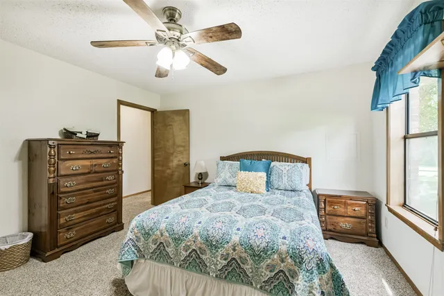 a bedroom with a bed next to a window and a chandelier