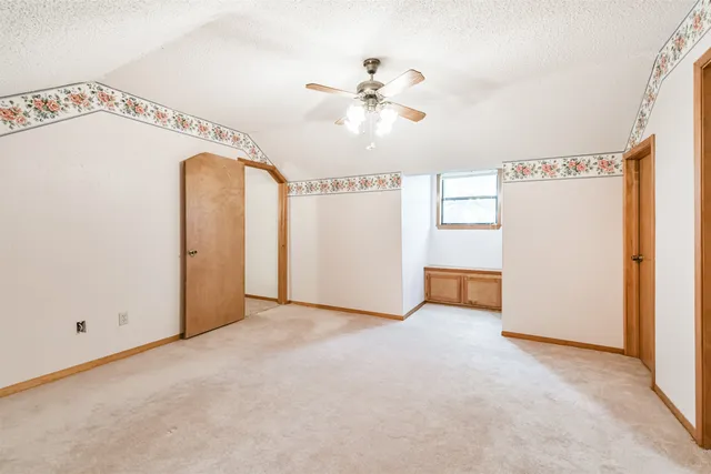 a view of a room with an entryway and chandelier fan
