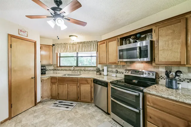 a kitchen with stainless steel appliances granite countertop a sink stove and refrigerator