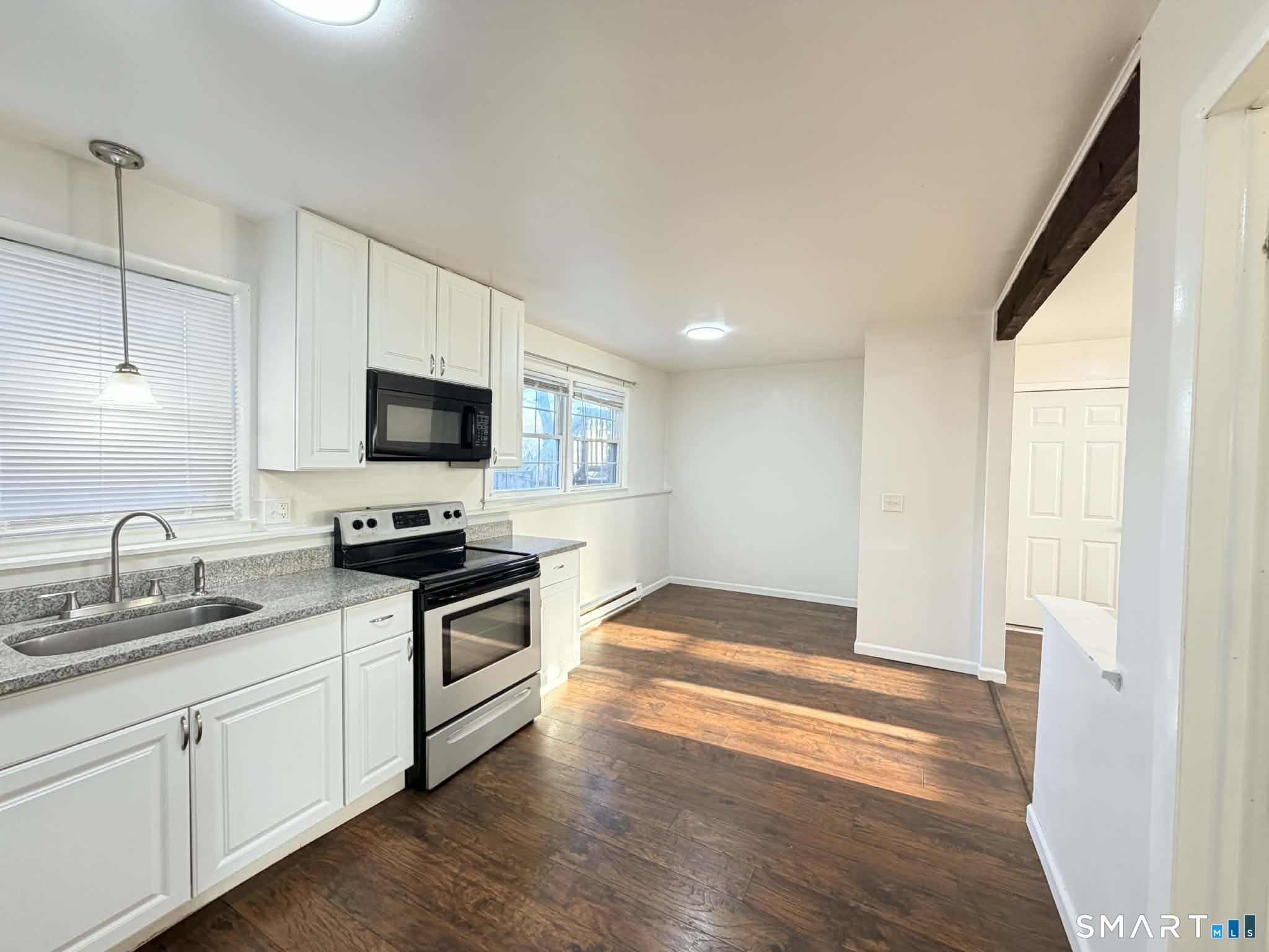 12 Terrace Place, Unit 2 New Milford, CT 06776 - Photo 2 of 11 a kitchen with granite countertop a sink wooden floor and stainless steel appliances