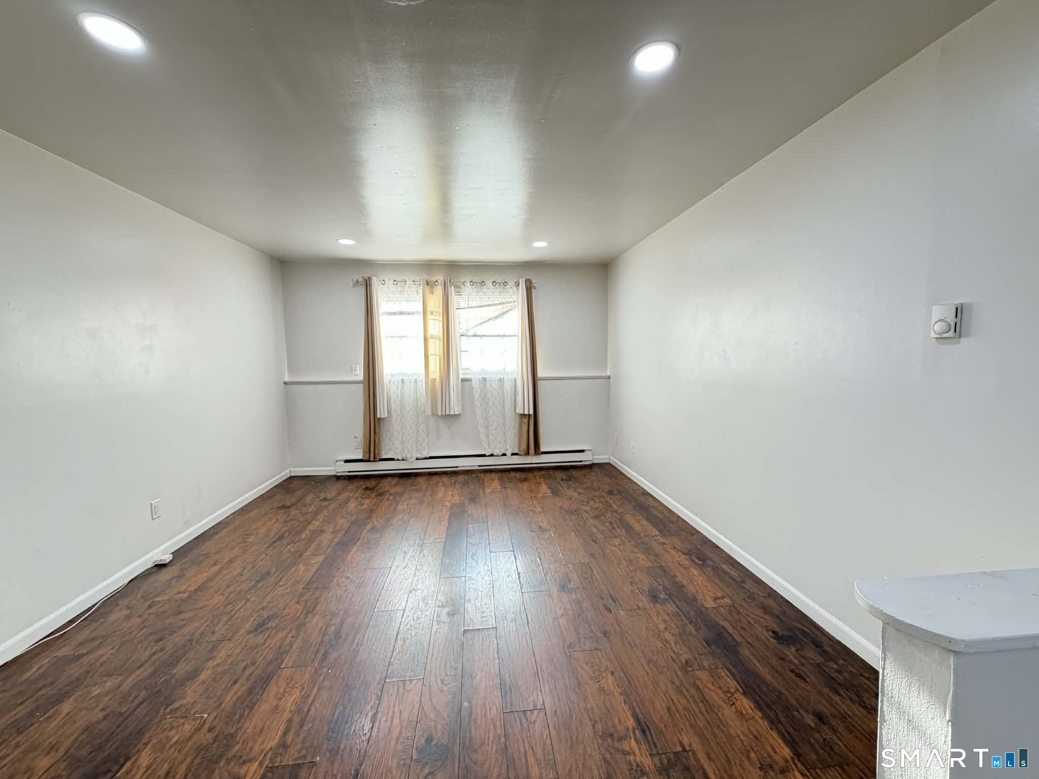 12 Terrace Place, Unit 2 New Milford, CT 06776 - Photo 7 of 11 an empty room with wooden floor and windows