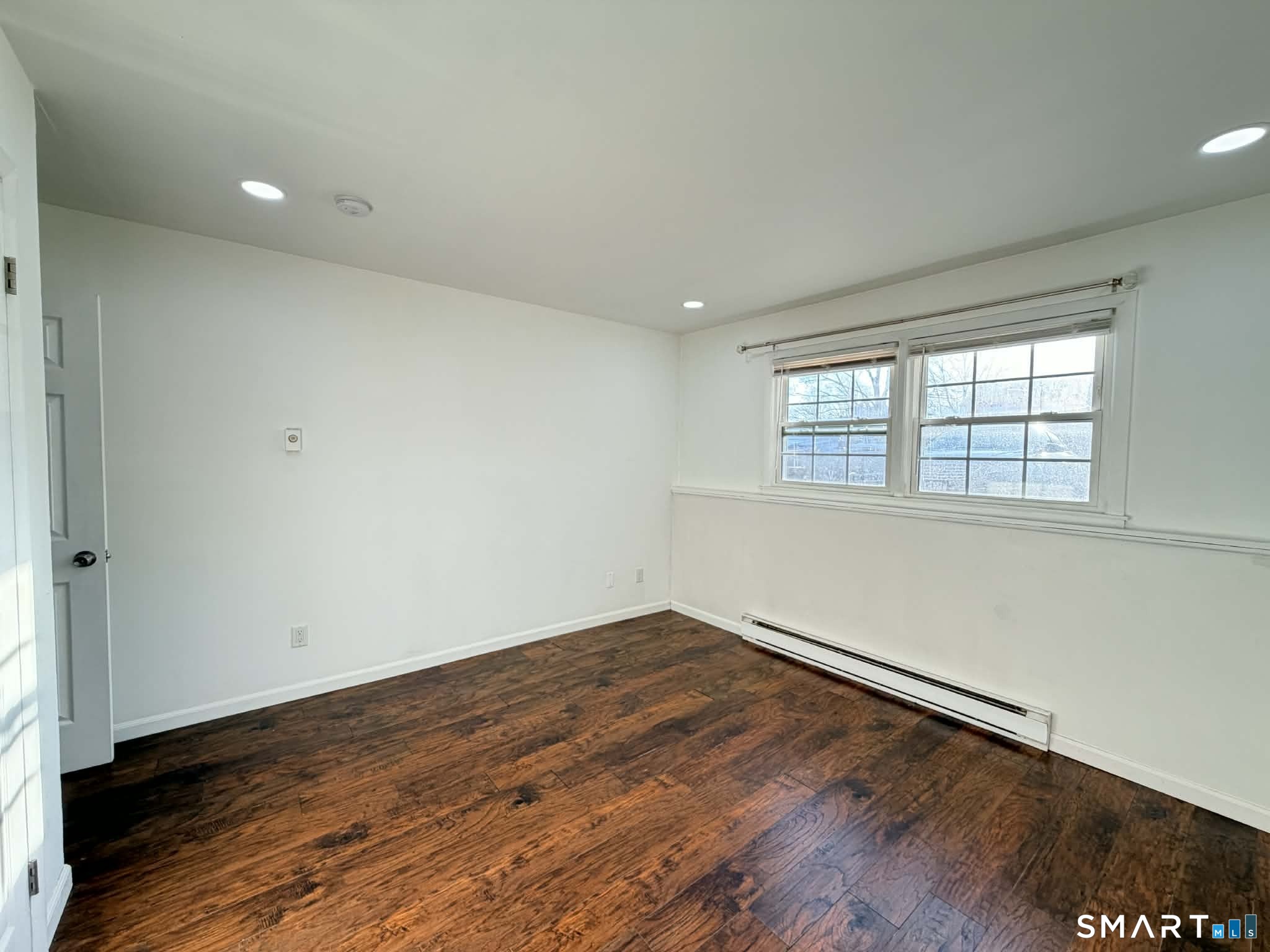 12 Terrace Place, Unit 2 New Milford, CT 06776 - Photo 8 of 11 an empty room with wooden floor and windows