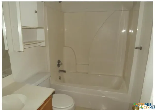 a bathroom with a toilet and a bath tub