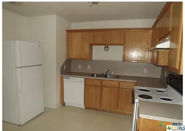 a kitchen with stainless steel appliances a sink stove and refrigerator