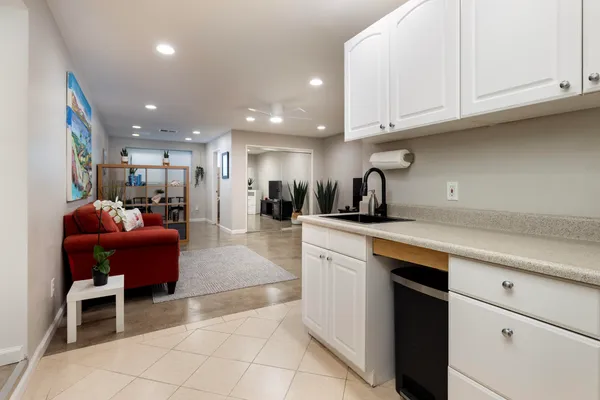 a kitchen with stainless steel appliances granite countertop a sink a stove a refrigerator and white cabinets