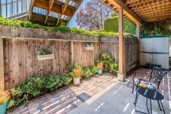 a view of a chair and table in backyard of the house
