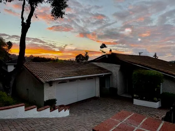 a view of house with backyard and a car park