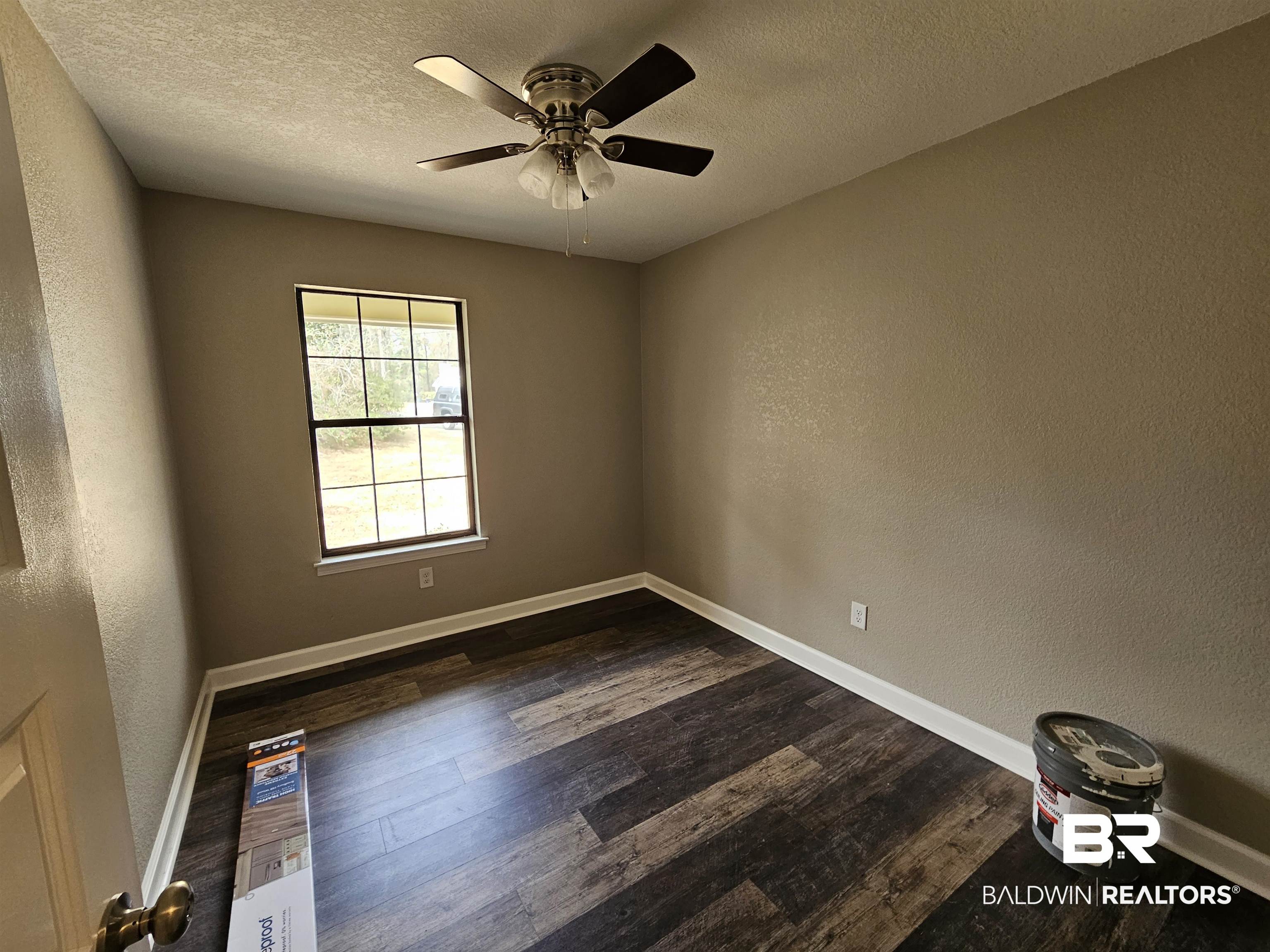 138 Wicker Way Daphne, AL 36526 - Photo 22 of 32 Spare room featuring a textured wall, dark wood finished floors, ceiling fan, and a textured ceiling