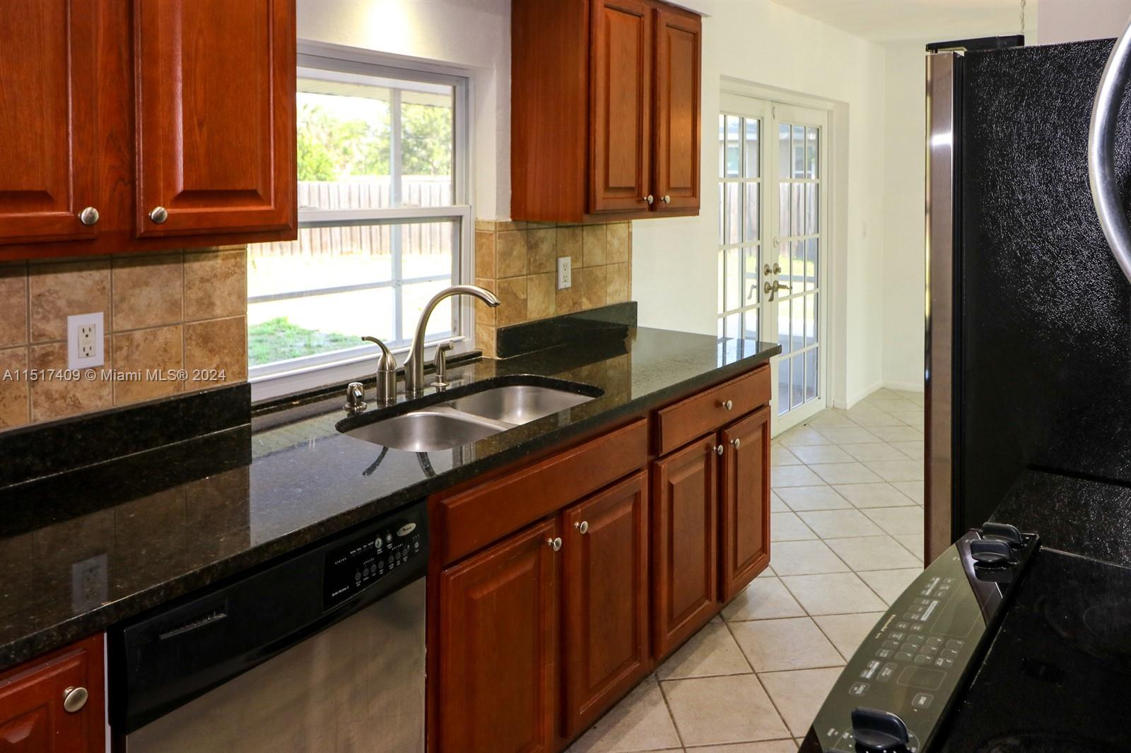 2139 Delta Street Port Charlotte, FL 33952 - Photo 13 of 43 a kitchen with granite countertop a sink stove and cabinets