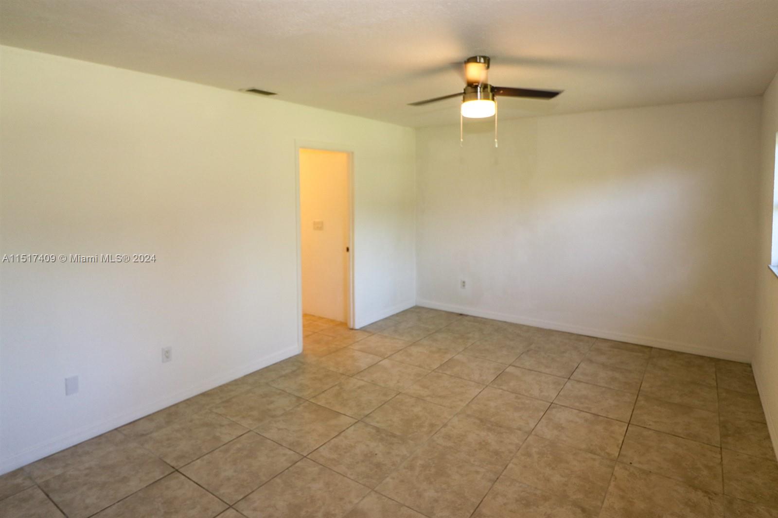 2139 Delta Street Port Charlotte, FL 33952 - Photo 21 of 43 an empty room with a chandelier fan and windows