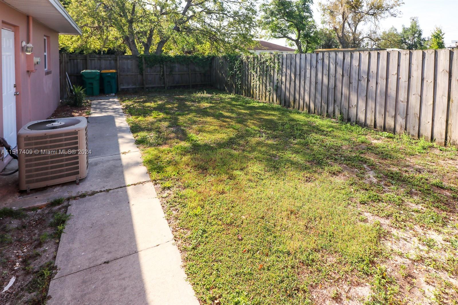 2139 Delta Street Port Charlotte, FL 33952 - Photo 42 of 43 a view of a yard with plants and wooden fence