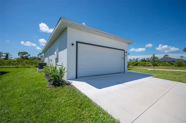 a view of a house with a yard and potted plants