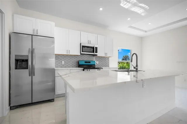 a kitchen with stainless steel appliances a refrigerator sink and microwave