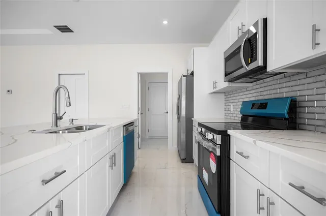 a kitchen with stainless steel appliances a sink and a stove top oven