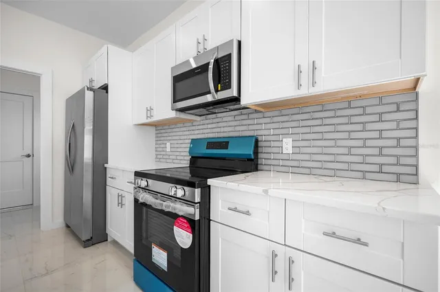 a kitchen with stainless steel appliances granite countertop a stove microwave and refrigerator