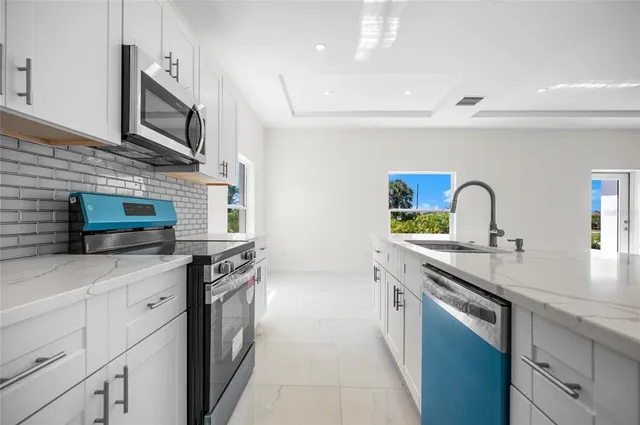 a kitchen with stainless steel appliances granite countertop a sink stove and microwave