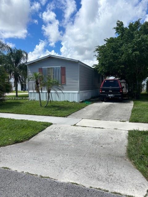 4087 Marigold Road Boynton Beach, FL 33436 - Photo 3 of 7 a front view of a house with a garden and trees