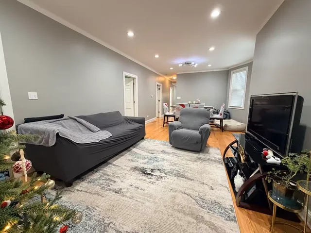 a living room with furniture a rug and a flat screen tv