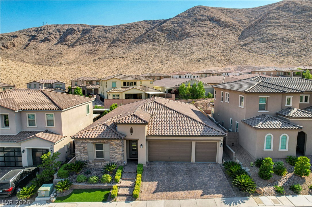 3943 Reyes Avenue Las Vegas, NV 89141 - Photo 66 of 95 A well-maintained single-story home with a two-car garage set against a picturesque mountain backdrop.
