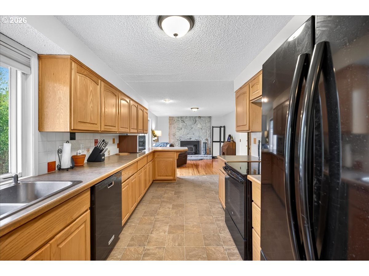 19650 Southwest Jaylee Street Beaverton, OR 97078 - Photo 22 of 46 a kitchen with stainless steel appliances granite countertop a refrigerator a sink dishwasher a stove and white cabinets with wooden floor