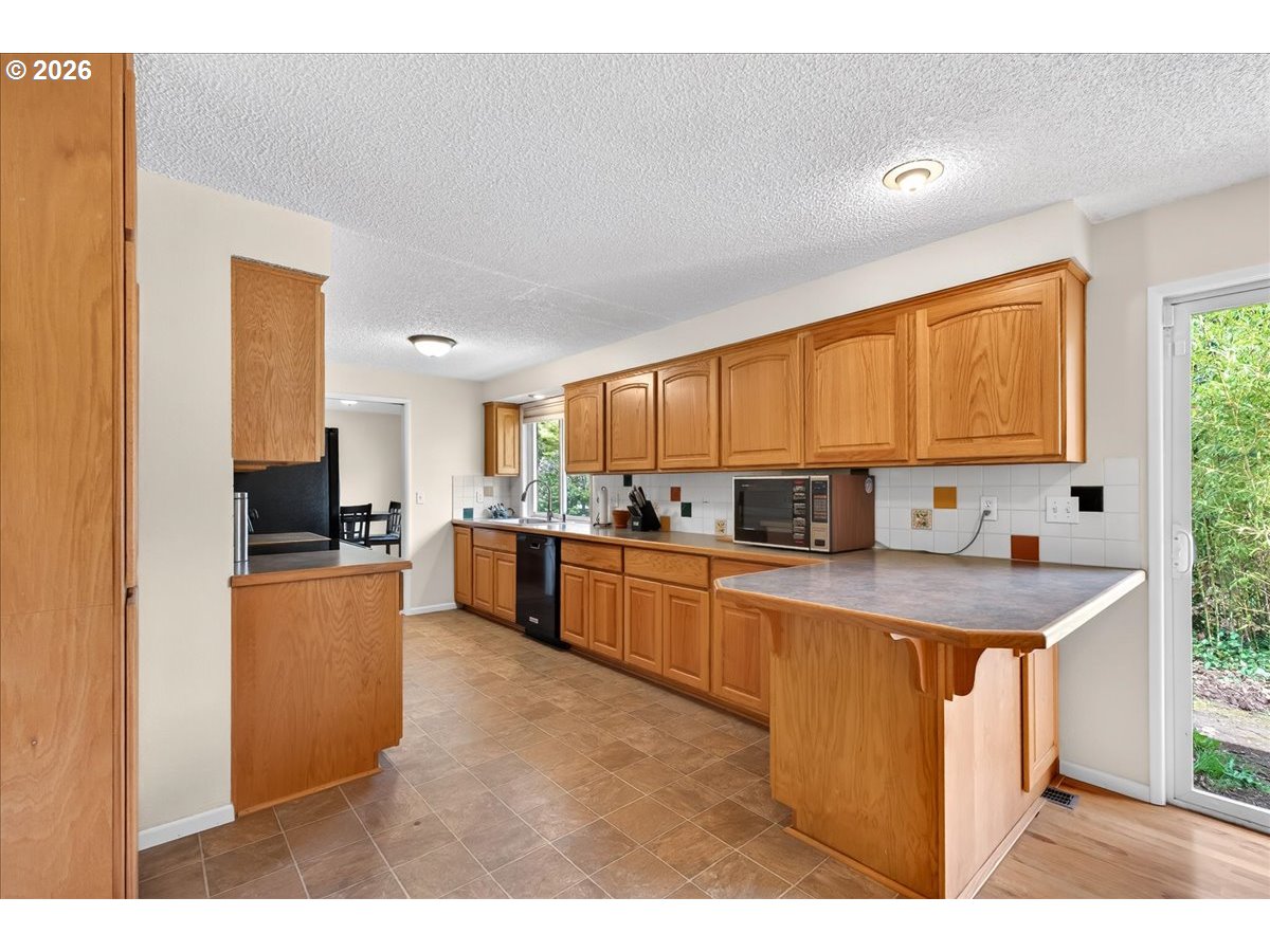 19650 Southwest Jaylee Street Beaverton, OR 97078 - Photo 24 of 46 a kitchen with stainless steel appliances granite countertop a stove a sink dishwasher and a refrigerator