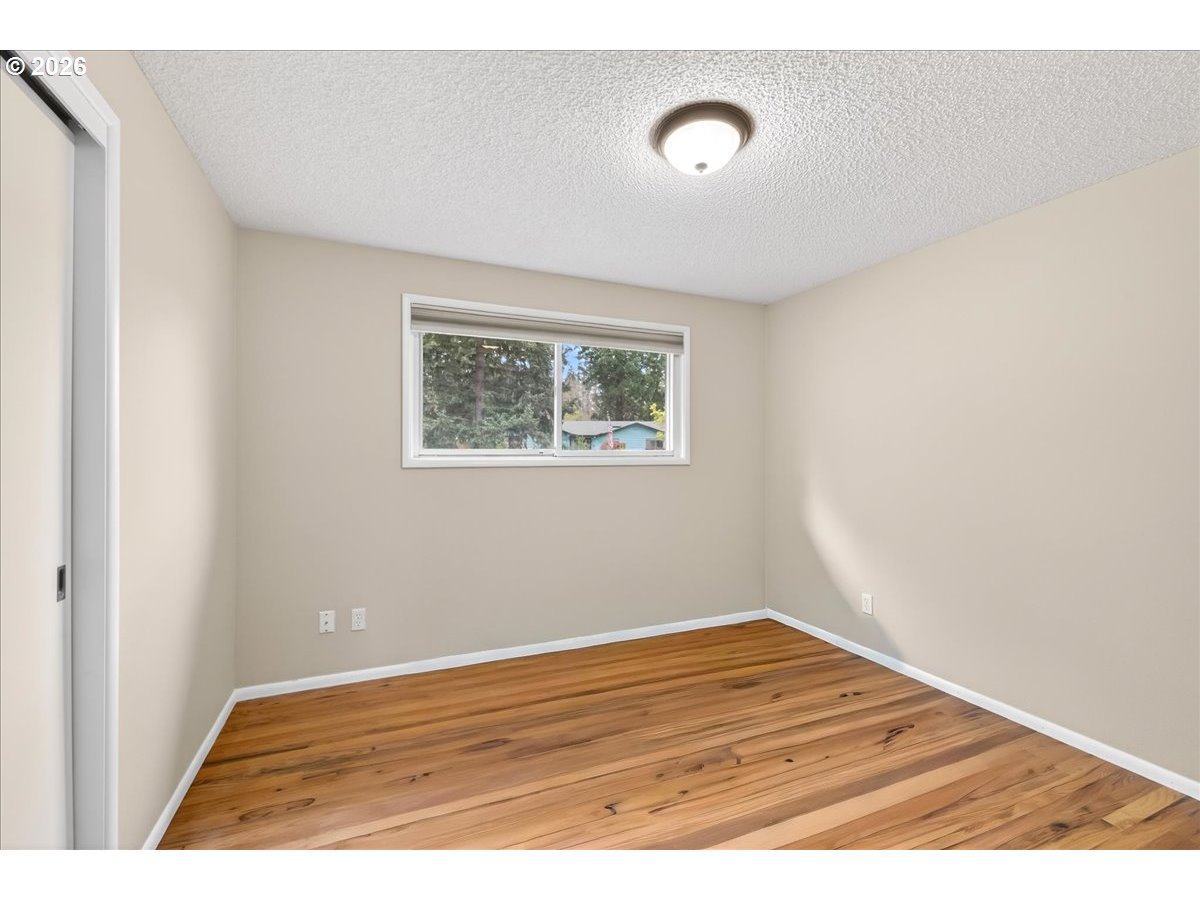 19650 Southwest Jaylee Street Beaverton, OR 97078 - Photo 33 of 46 a view of an empty room with wooden floor and a window