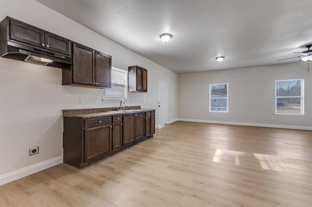 711 South 3rd Avenue East Dawson, TX 76639 - Photo 6 of 12 a kitchen with stainless steel appliances granite countertop a stove a sink and a refrigerator