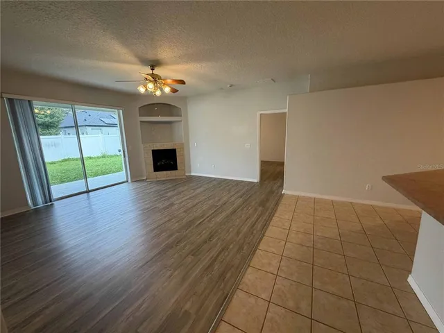 an empty room with large windows and a fireplace