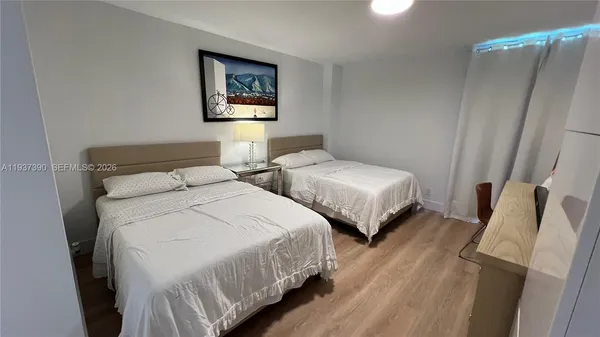 a bedroom with two beds and painting on the wall