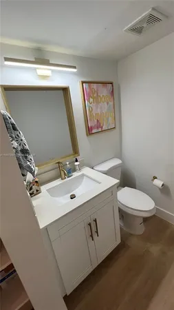 a bathroom with a sink mirror vanity and toilet
