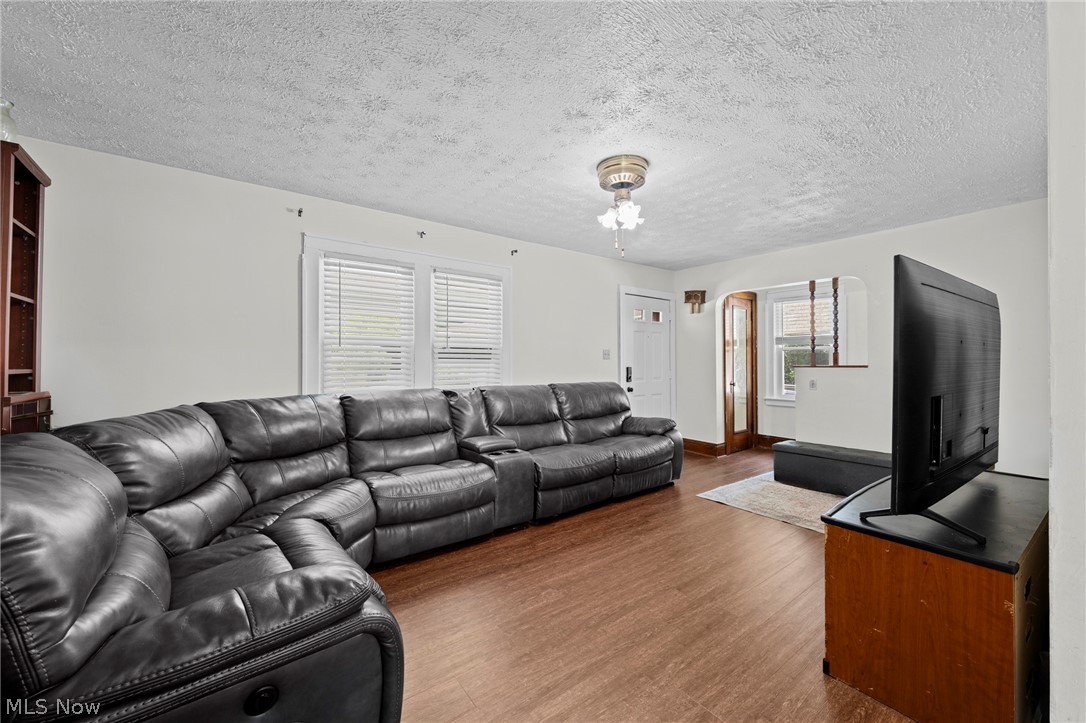 819 Keeney Street Akron, OH 44310 - Photo 7 of 24 Light-filled living area featuring wood-finish flooring, white walls, and a textured ceiling