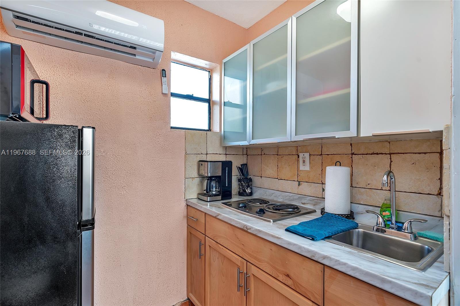 322 Harding Street, Unit B202 Hollywood, FL 33019 - Photo 34 of 39 a kitchen with a sink and a stove next to a window