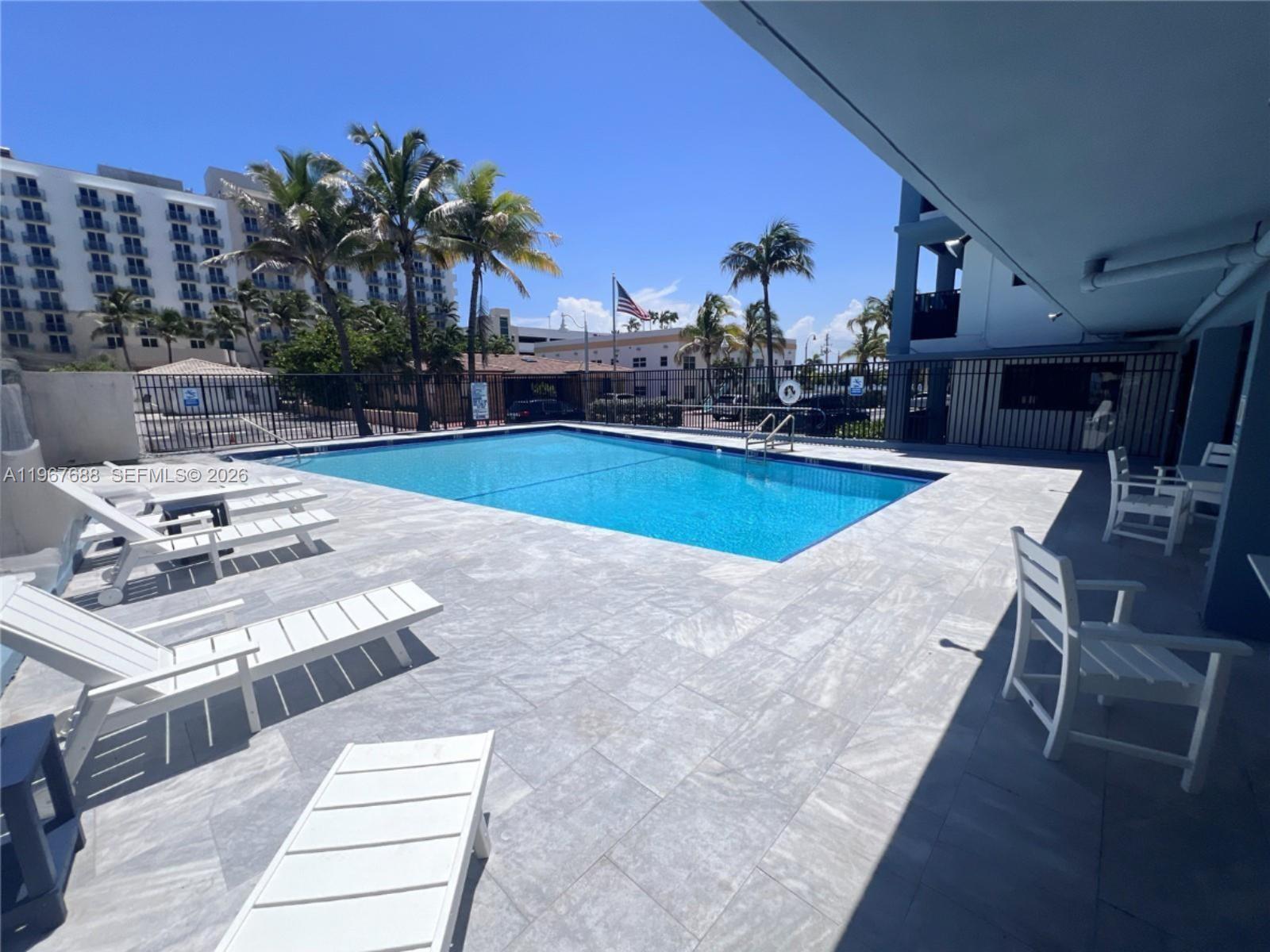 322 Harding Street, Unit B202 Hollywood, FL 33019 - Photo 37 of 39 a view of a swimming pool with lounge chairs