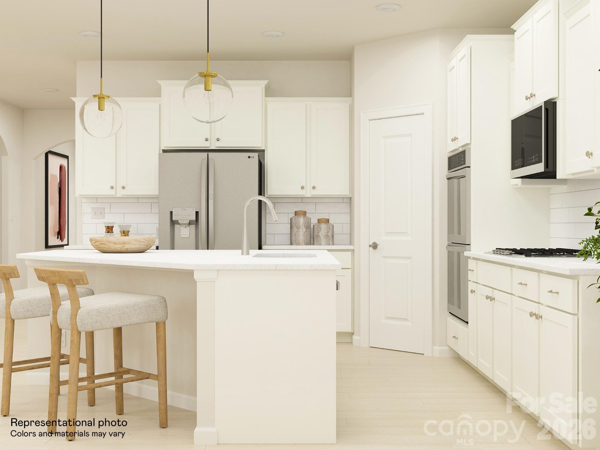 a kitchen with stainless steel appliances a stove a sink and white cabinets