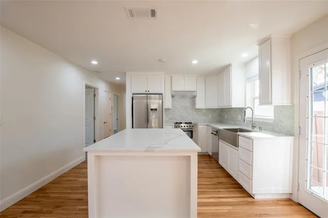 a kitchen with stainless steel appliances a refrigerator sink and stove