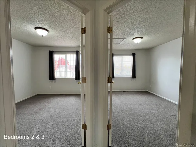 an empty room with windows and closet