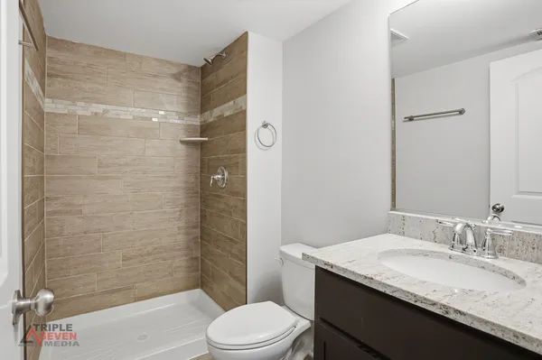 a bathroom with a granite countertop sink toilet and shower