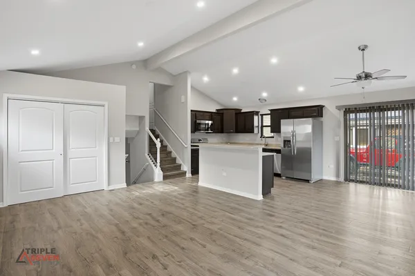 a view of a kitchen with a sink refrigerator and wooden floor