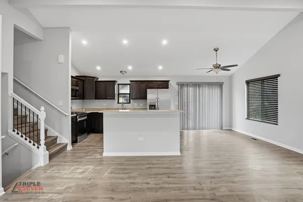 a view of kitchen with kitchen island microwave oven stove and oven