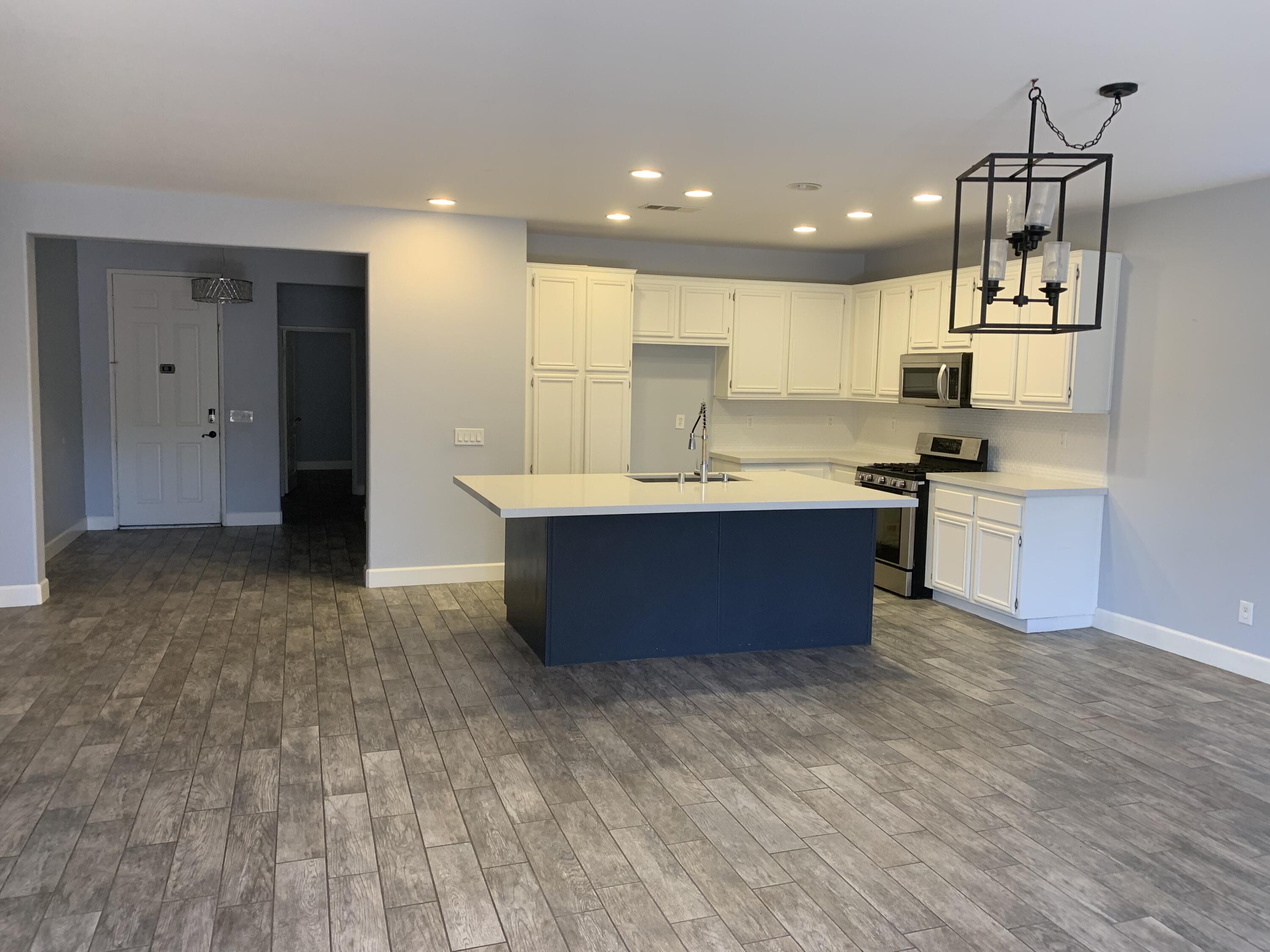 4036 Jonathon Street Lancaster, CA 93536 - Photo 2 of 3 a kitchen with kitchen island a sink stainless steel appliances and cabinets