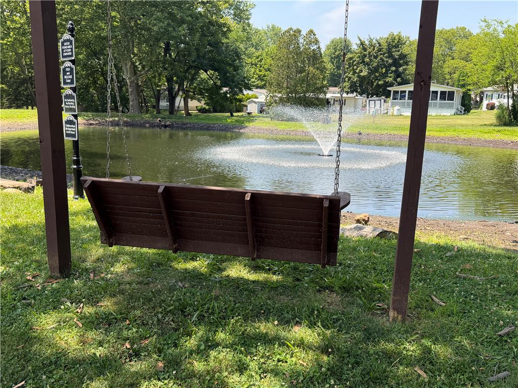 12 Springridge Road Bath, PA 18014 - Photo 65 of 70 A tranquil pond with a decorative fountain creates a serene backdrop for a swing bench.