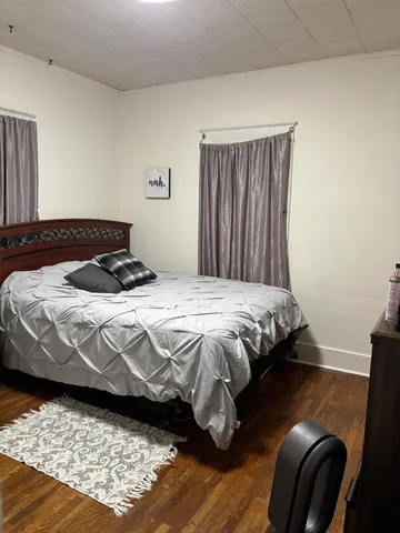 a bedroom with a bed and wooden floor