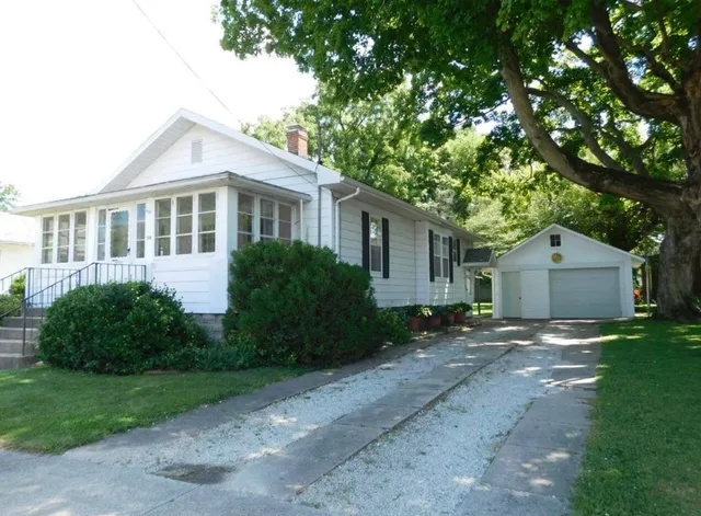 a view of a yard in front of a house with large windows