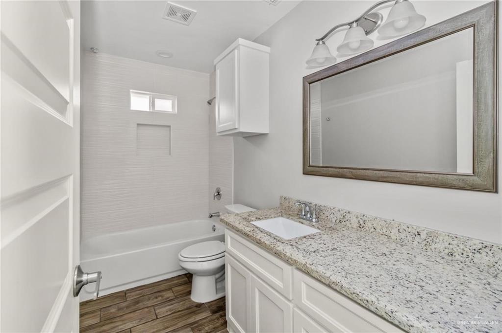 2011 Stardust Lane, Unit 4 Edinburg, TX 78541 - Photo 8 of 10 a bathroom with a granite countertop sink toilet a mirror and bathtub