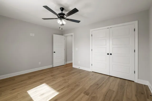 a view of an empty room with wooden floor