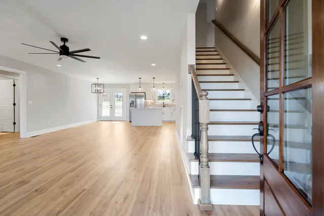 a view of staircase and kitchen with wooden floor