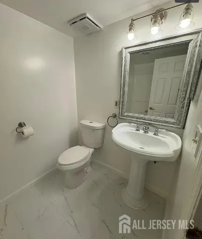 a bathroom with a sink toilet and mirror