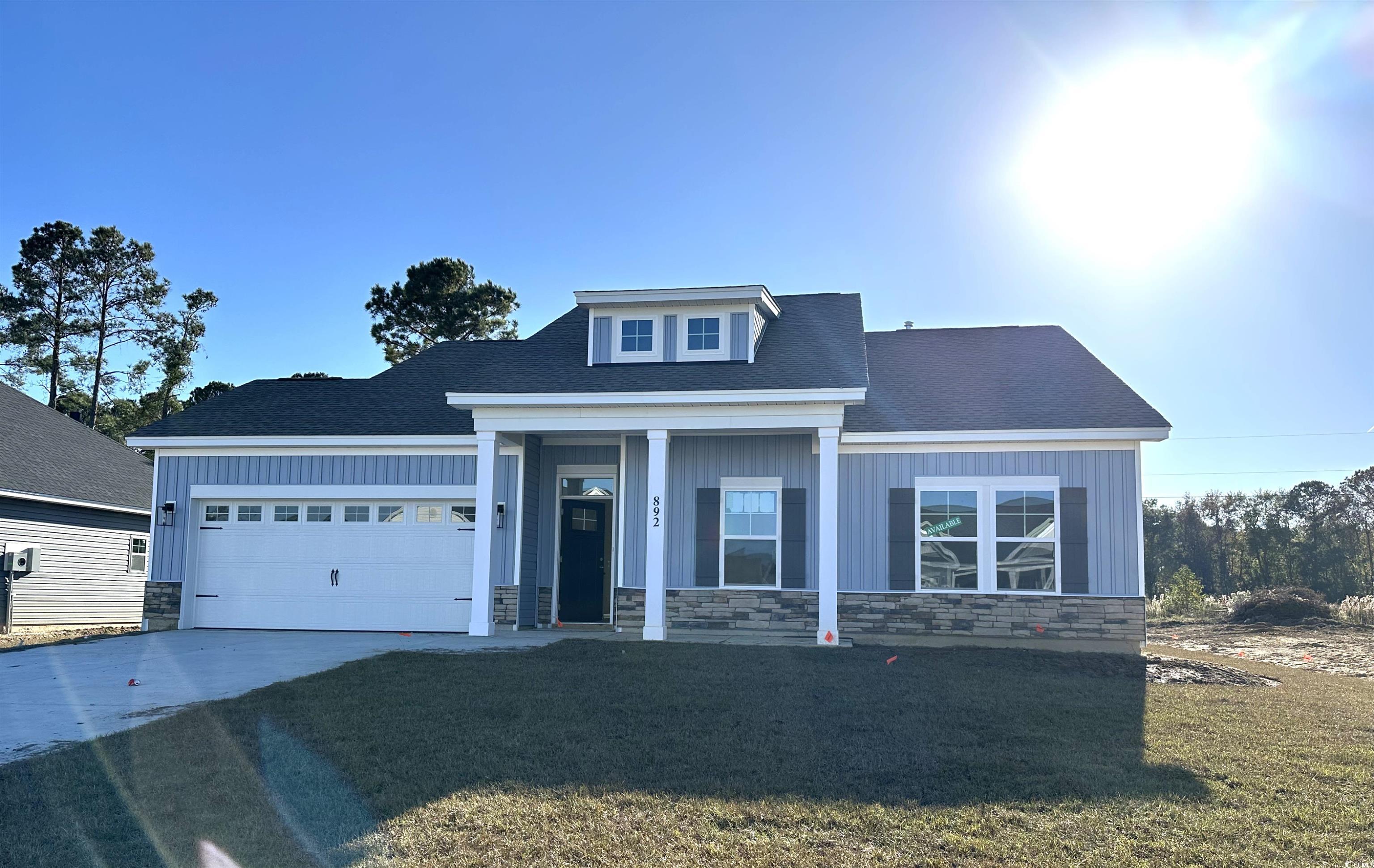 View of front of property featuring a porch, a front lawn, and stone siding