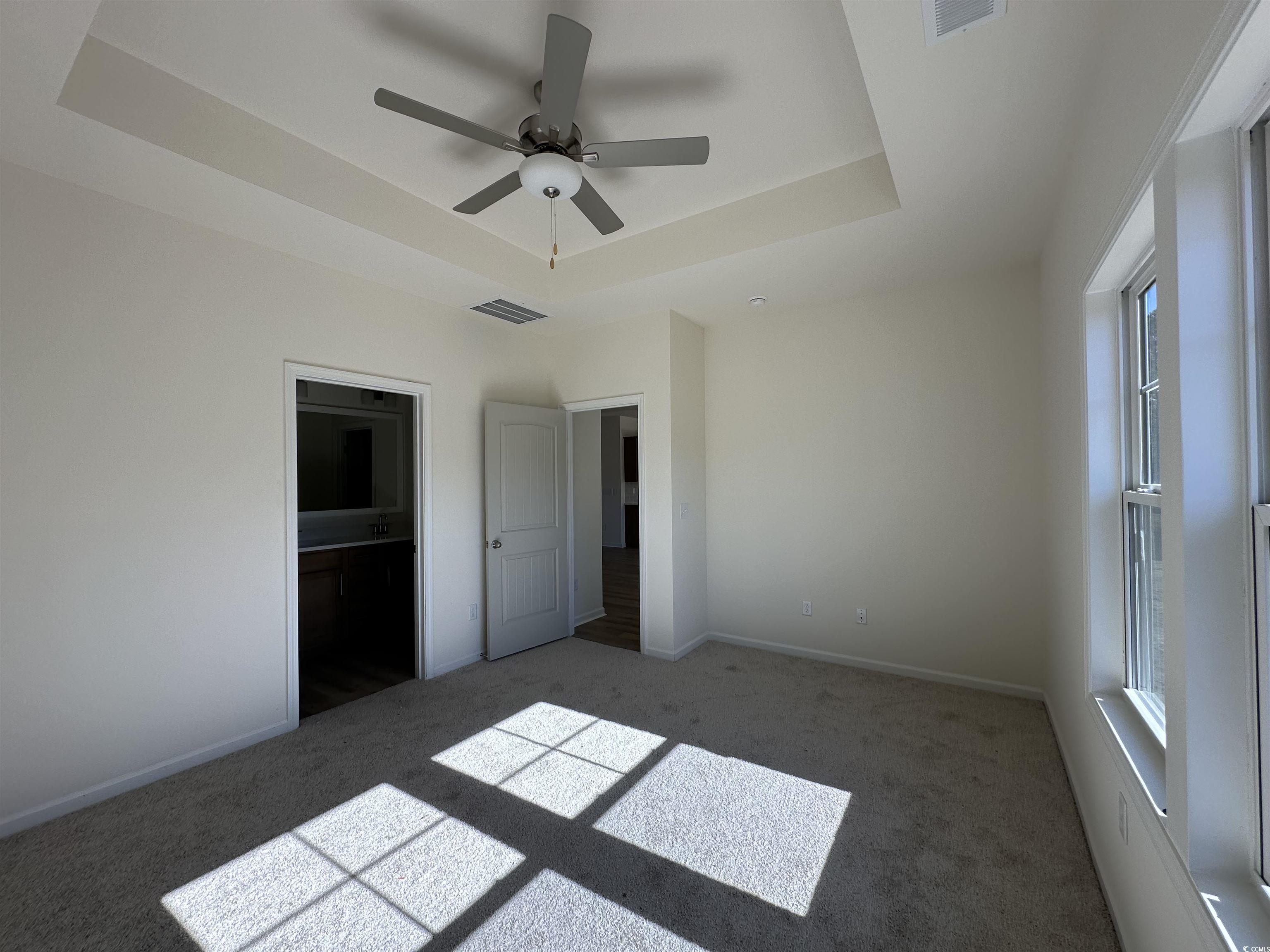 892 Birch Gdn Drive Longs, SC 29568 - Photo 6 of 15 Unfurnished bedroom featuring a raised ceiling, carpet floors, ceiling fan, and connected bathroom